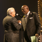 Men shake hands on stage